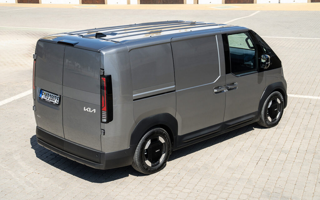 Photo of a parked KIA PV5 Cargo van, seen in angled profile from the rear.